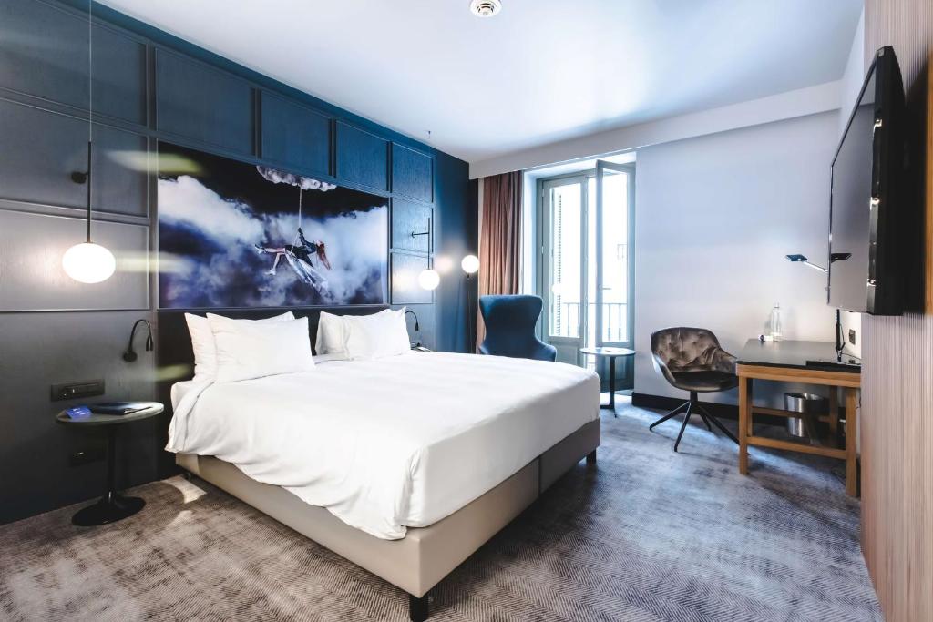 马德里马德里普拉多丽笙酒店的酒店客房设有一张大床和一张书桌。