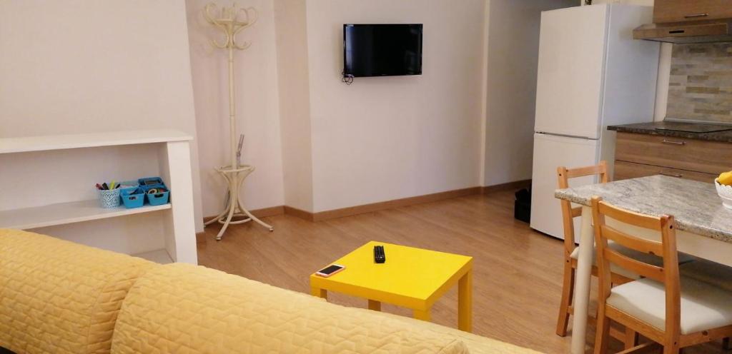 斯波莱托La Fontana的一间带黄色沙发的客厅和一间厨房