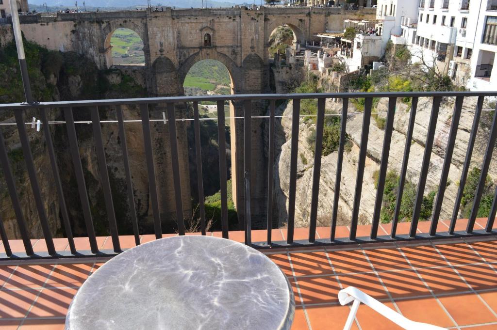 隆达卡萨魔力德尔塔霍酒店的阳台的桌子,享有桥梁的景色
