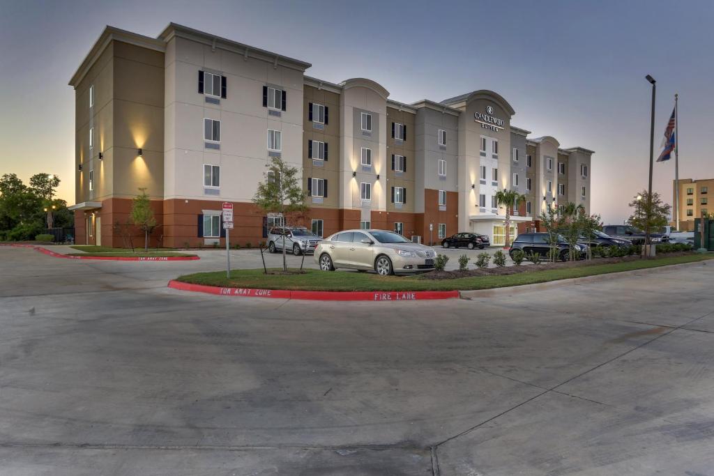 布赖恩Candlewood Suites College Station, an IHG Hotel的停在大楼前停车场的汽车