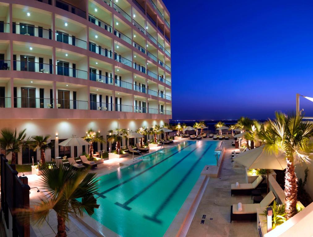 阿布扎比阿布扎比亚斯岛驻桥套房假日酒店的晚上在酒店前面的一个游泳池