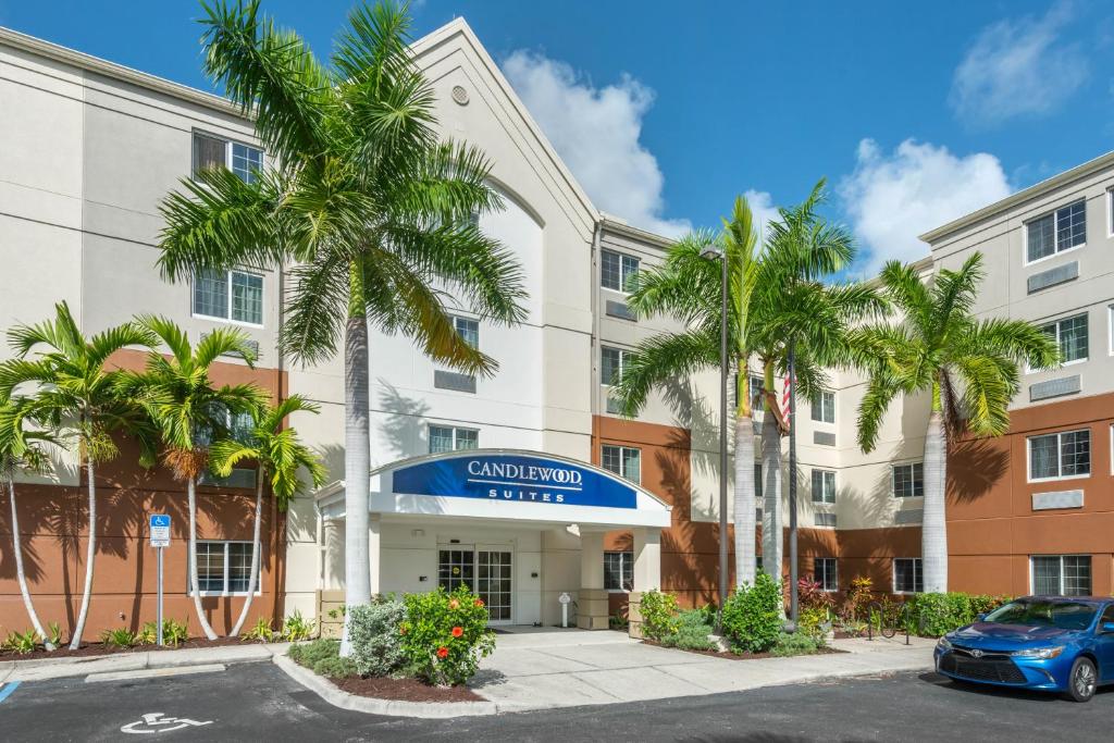 迈尔斯堡Candlewood Suites Fort Myers/Sanibel Gateway, an IHG Hotel的棕榈树酒店前方的图象