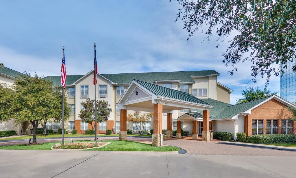 达拉斯Candlewood Suites Dallas Market Center-Love Field, an IHG Hotel的前面有美国国旗的建筑