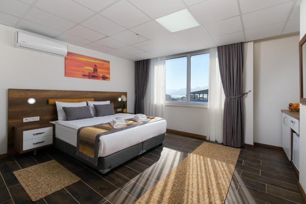 安塔利亚Grand Gulluk Hotel & Spa的酒店客房设有一张床和一个大窗户