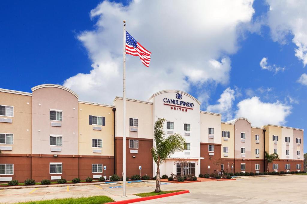 德克萨斯城Candlewood Suites - Texas City, an IHG Hotel的前面有美国国旗的酒店