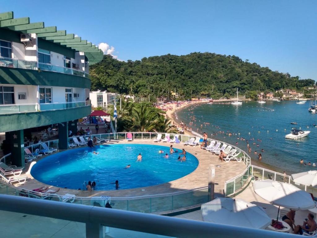 安格拉杜斯雷斯angra dos reis, condomínio angra inn的海滩上的游泳池,人们在水中