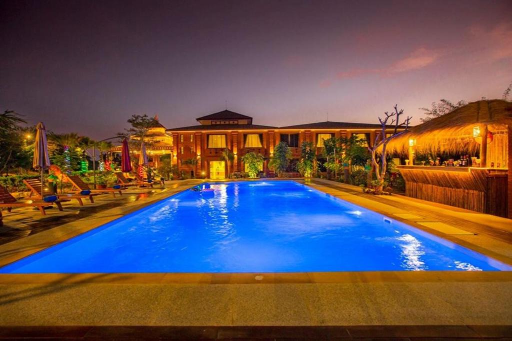 蒲甘Acacia Hotel Bagan的一座大蓝色游泳池,位于房子前