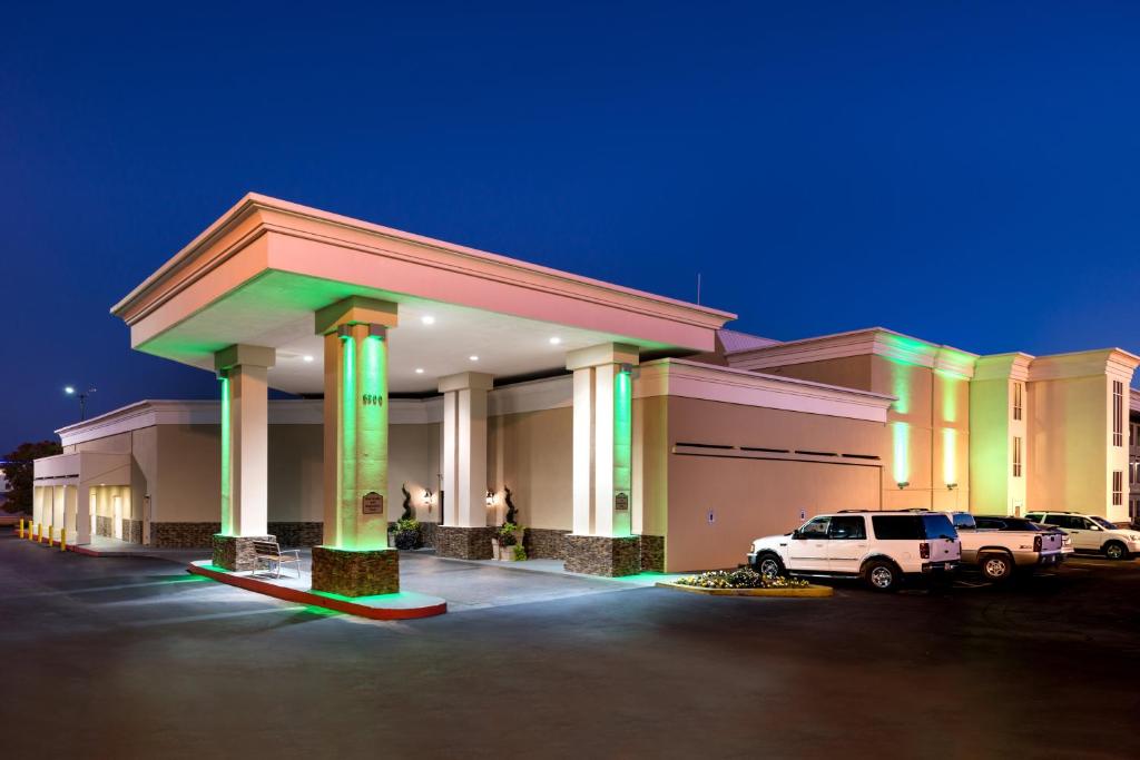 俄克拉何马城Holiday Inn Hotel & Suites Oklahoma City North, an IHG Hotel的停车场内有停车位的大型建筑