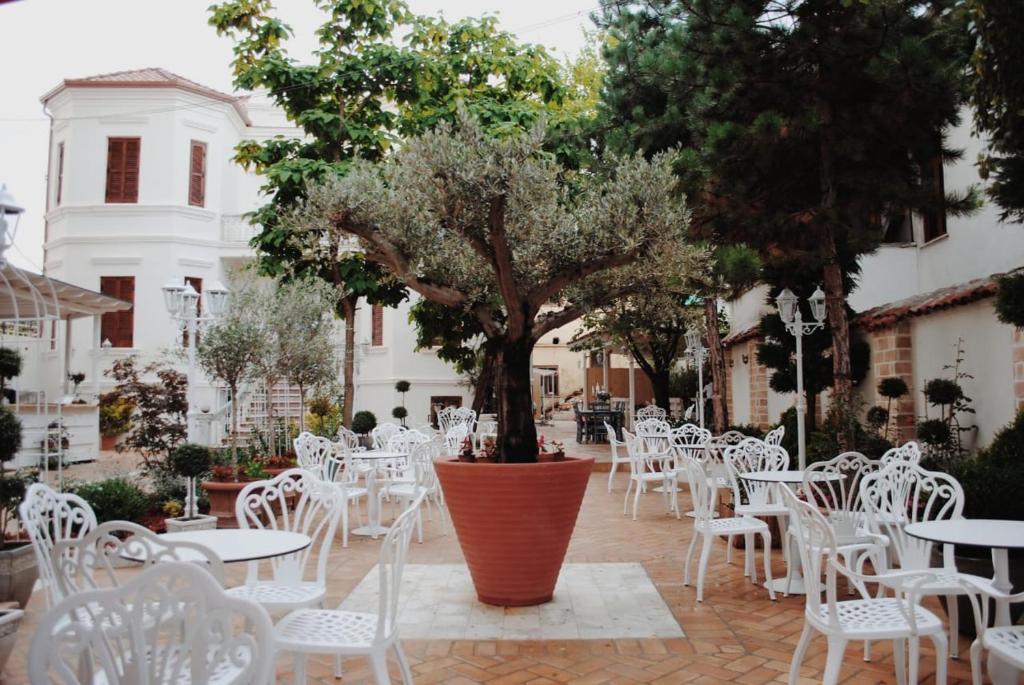 波格拉德茨Garden Villa Boutique Hotel的庭院配有白色的桌椅和一棵树