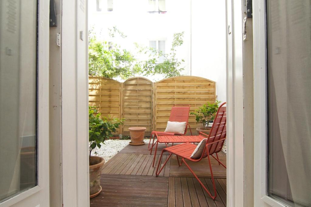 巴黎Studio Falguiere avec terrasse proche Necker et Montparnasse的阳台配有红色椅子和桌椅。