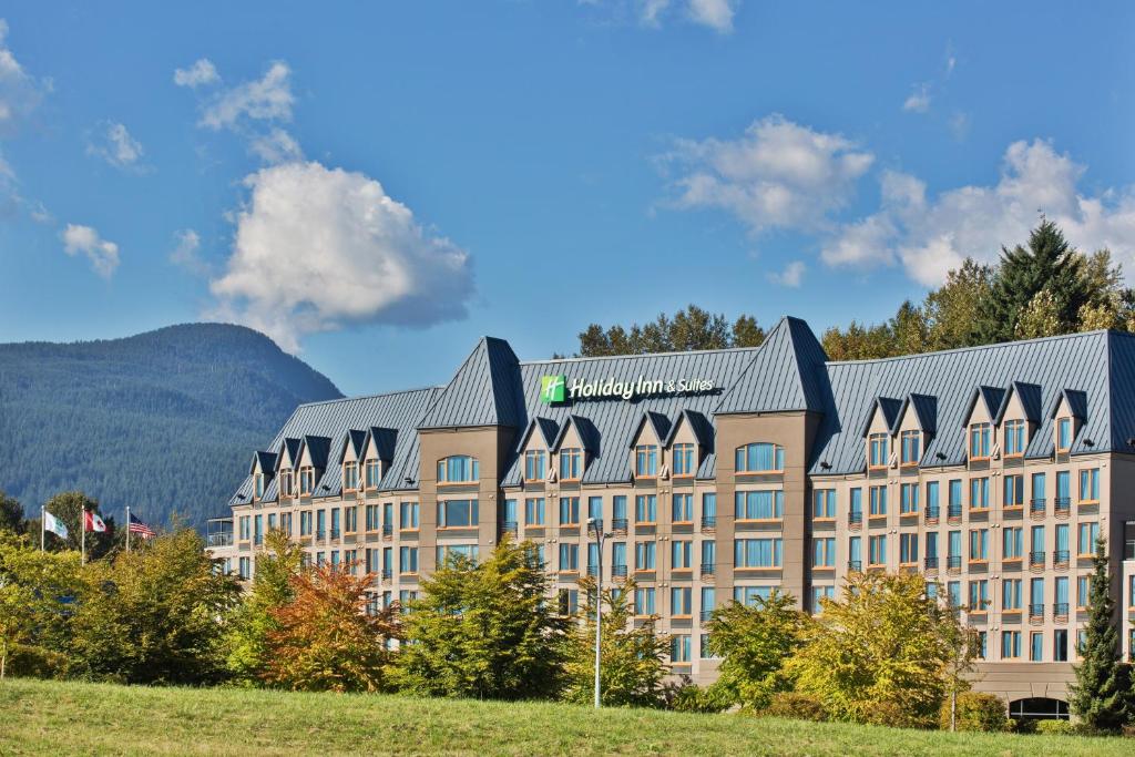 北温哥华Holiday Inn & Suites North Vancouver, an IHG Hotel的一座大建筑,背景是一座山