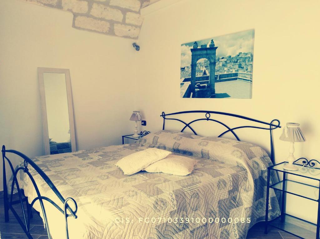 圣安吉罗山Le Casette nel Rione的卧室配有一张床,墙上挂着一幅画
