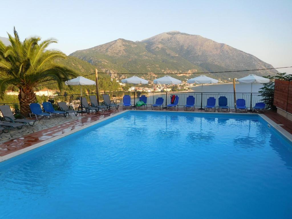 波罗斯Hotel Oceanis的一座大游泳池,后面是一座山
