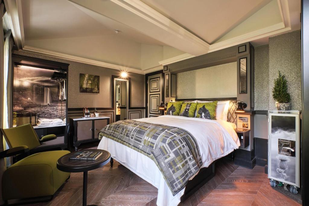 伦敦The Gyle的配有一张床和一把椅子的酒店客房