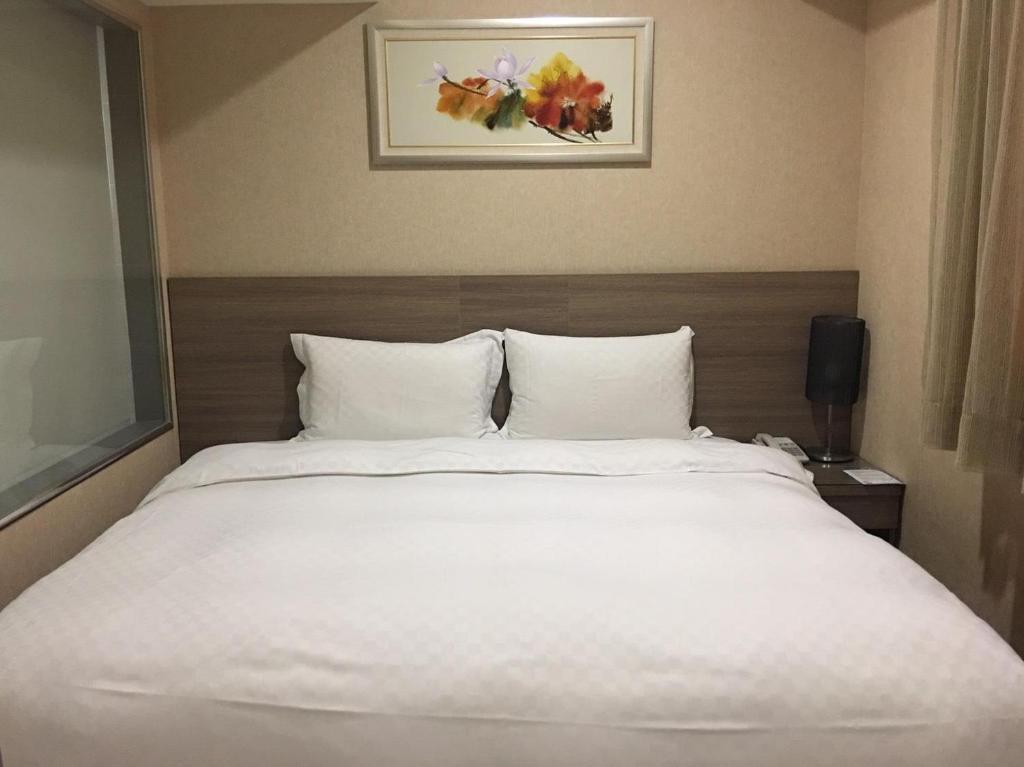 台中市豪爵大饭店台中馆的一张大白色的床,位于酒店客房内