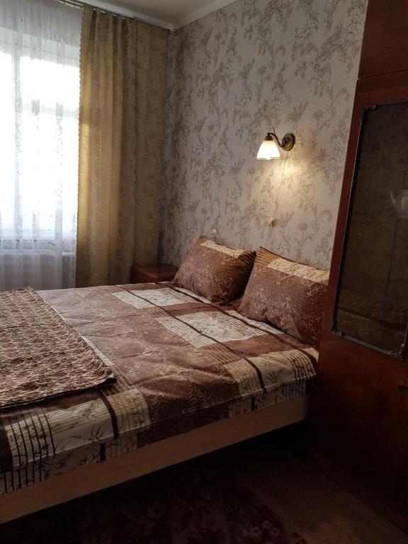 切尔尼戈夫Уютная квартира посуточно улица Белова的一间卧室配有一张带灯和窗户的床