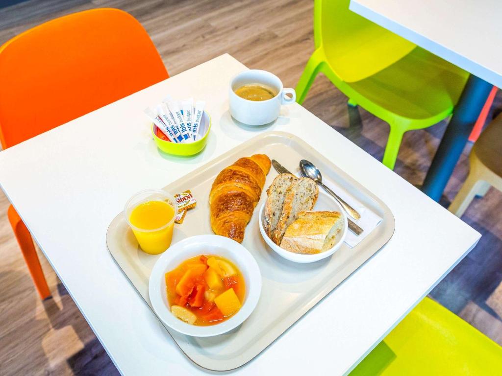 科洛米耶图卢科洛米耶宜必思快捷酒店的桌上的食品托盘,包括面包和水果
