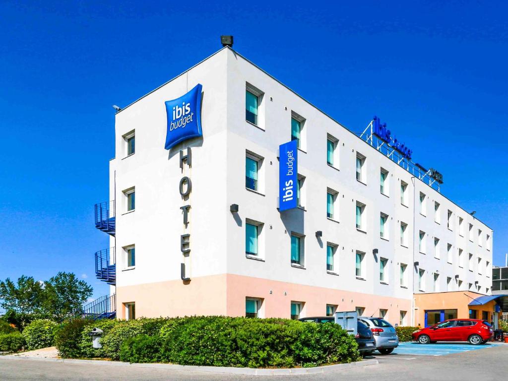 维特罗勒维托尔宜必思经济型酒店的一座白色的大建筑,上面有蓝色的标志