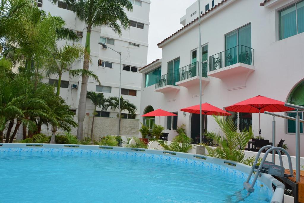 萨利纳斯Hotel Casablanca CHIPIPE的一座带红伞的建筑前的游泳池