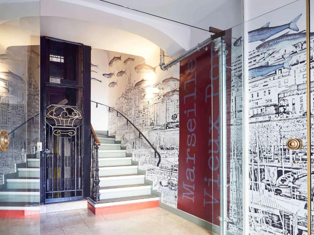 马赛马赛旧港宜必思尚品酒店的走廊上设有楼梯,墙上涂有涂鸦
