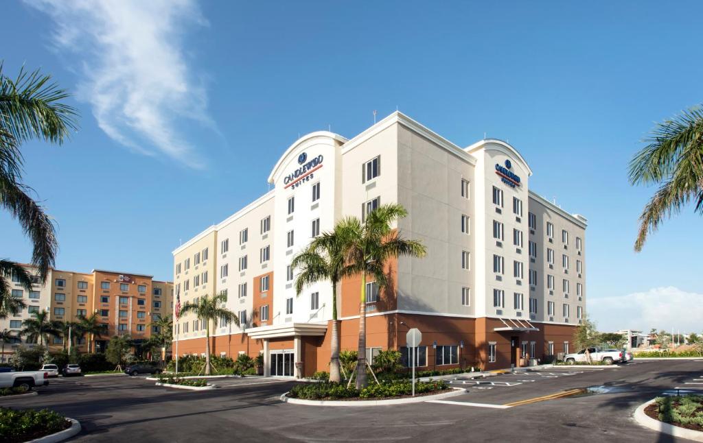 肯代尔Candlewood Suites - Miami Exec Airport - Kendall, an IHG Hotel的街道前有棕榈树的酒店