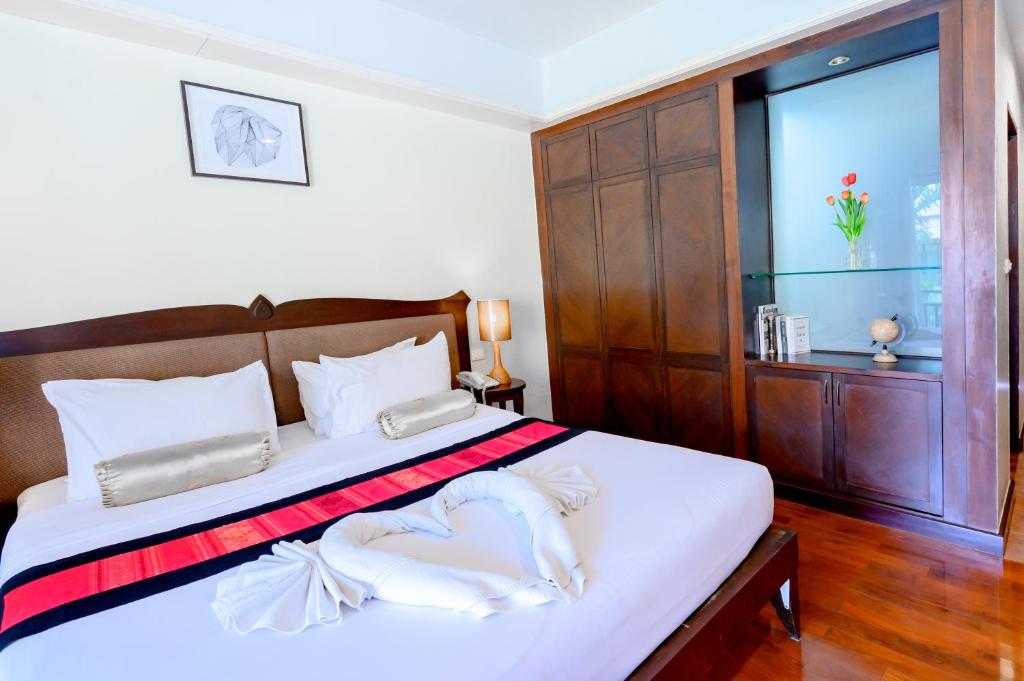 邦盛乐萨萨邦盛酒店 的一间卧室配有一张带白色床单的床和一扇窗户。