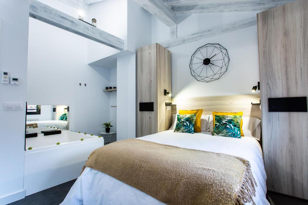 埃尔瓦Apartamentos Hervás Suites的一间带大床的卧室和一间浴室