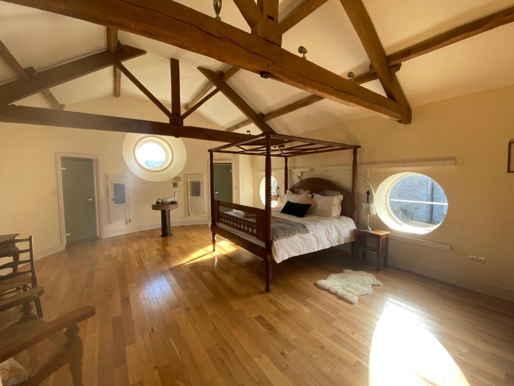 GlasburyGlanhenwye Courtyard Cottages的铺有木地板的客房内设有一间卧室和一张床。