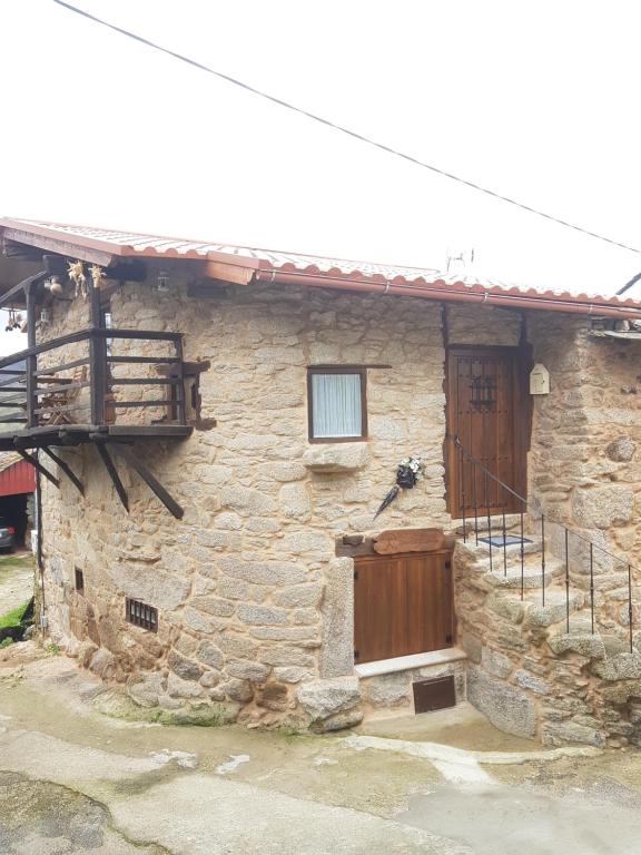Sas de PenelasA Paragűeria的石头房子,设有木门和阳台