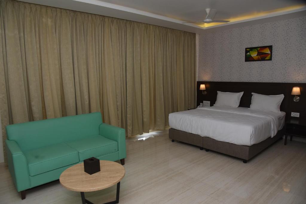 乌杜皮Fortune Plaza Hotel的酒店客房,配有床和沙发