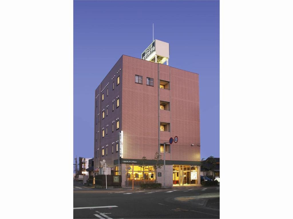藤枝Fujieda Ogawa Hotel フジエダオガワホテル的一条高大的棕色建筑,街上有窗户