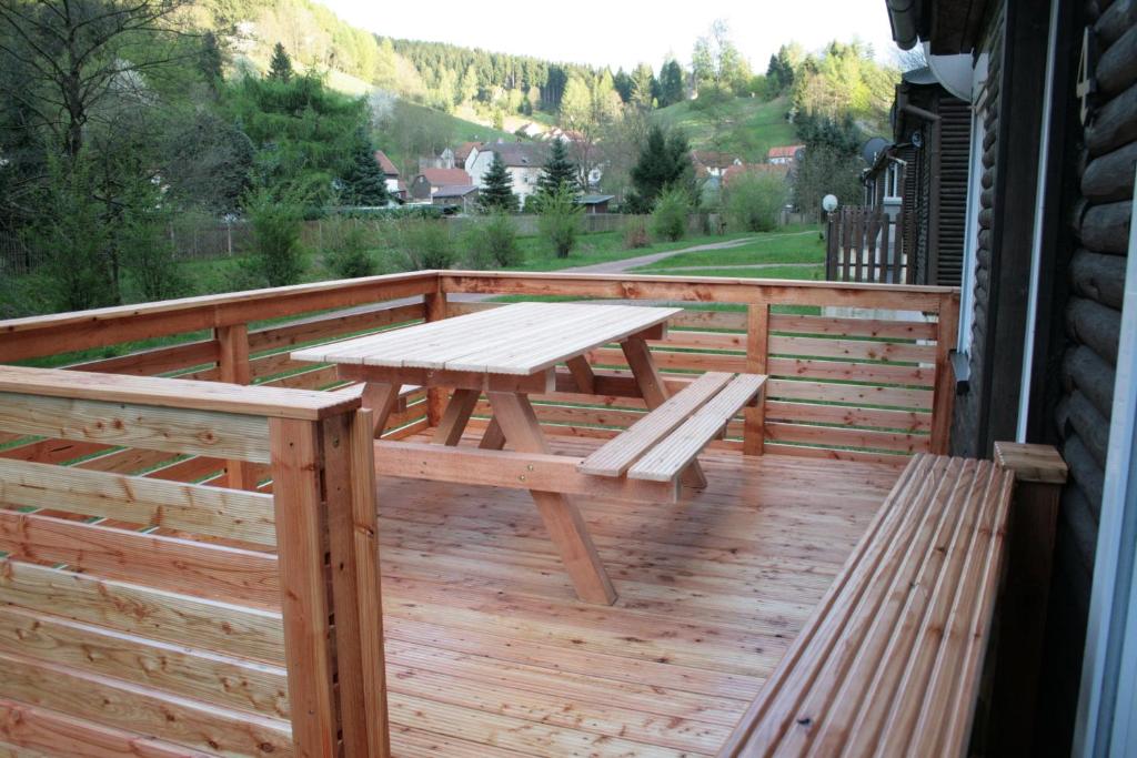 卢森塔尔Ferienhäuser Ohratalsperre的木甲板上设有野餐桌和长凳