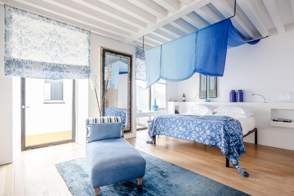 蒙福尔特Torre de Palma Wine Hotel, Montforte, a Member of Design Hotels的一间卧室配有蓝色窗帘、一张床和椅子