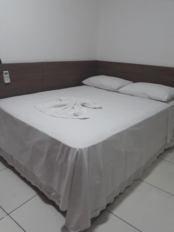 特雷西纳Pousada Pampa Gaúcho的一张带白色床单和白色枕头的床