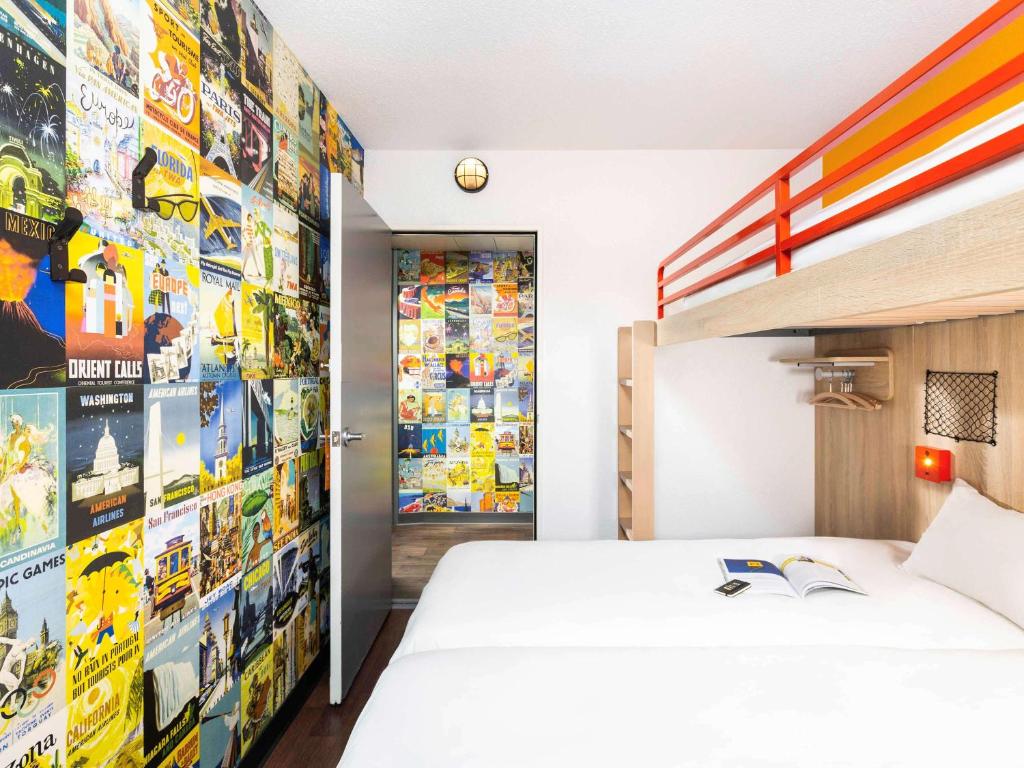 维勒纳夫多尔农hotelF1 Bordeaux Sud Villenave d'Ornon的一间卧室配有一张床和一堵贴纸墙
