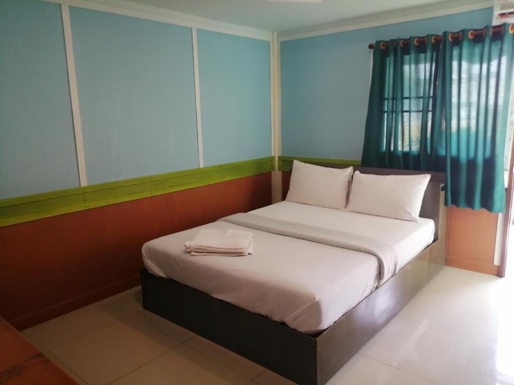 Ban Khok Mai Den (1)Nang Phraya Resort的一间小卧室,配有白色床单