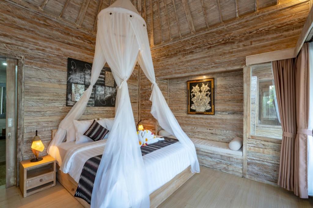 蓝梦岛Helly's Secret Garden Cottage的一间卧室配有一张带蚊帐的床