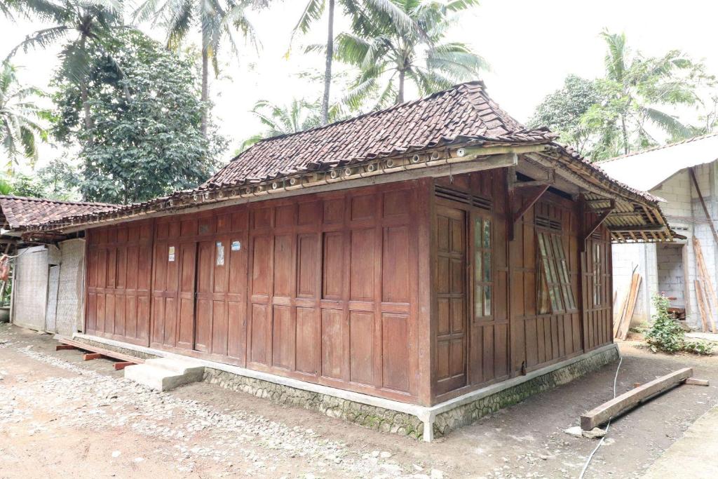 SermoHomestay Mbah Parni的房屋前的小木头建筑
