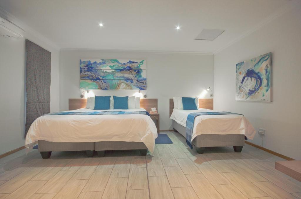 伊登维尔总统旅舍的一间卧室配有两张带蓝色枕头的床