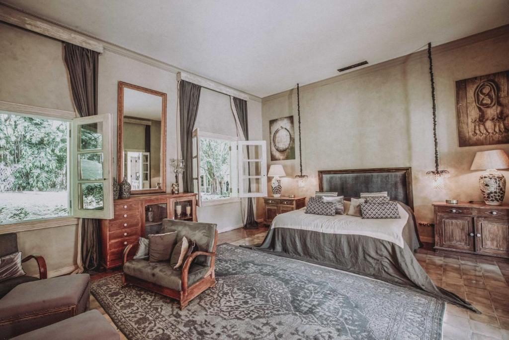 金巴兰巴曲斯别墅酒店的一间卧室配有一张床、一把椅子和窗户。