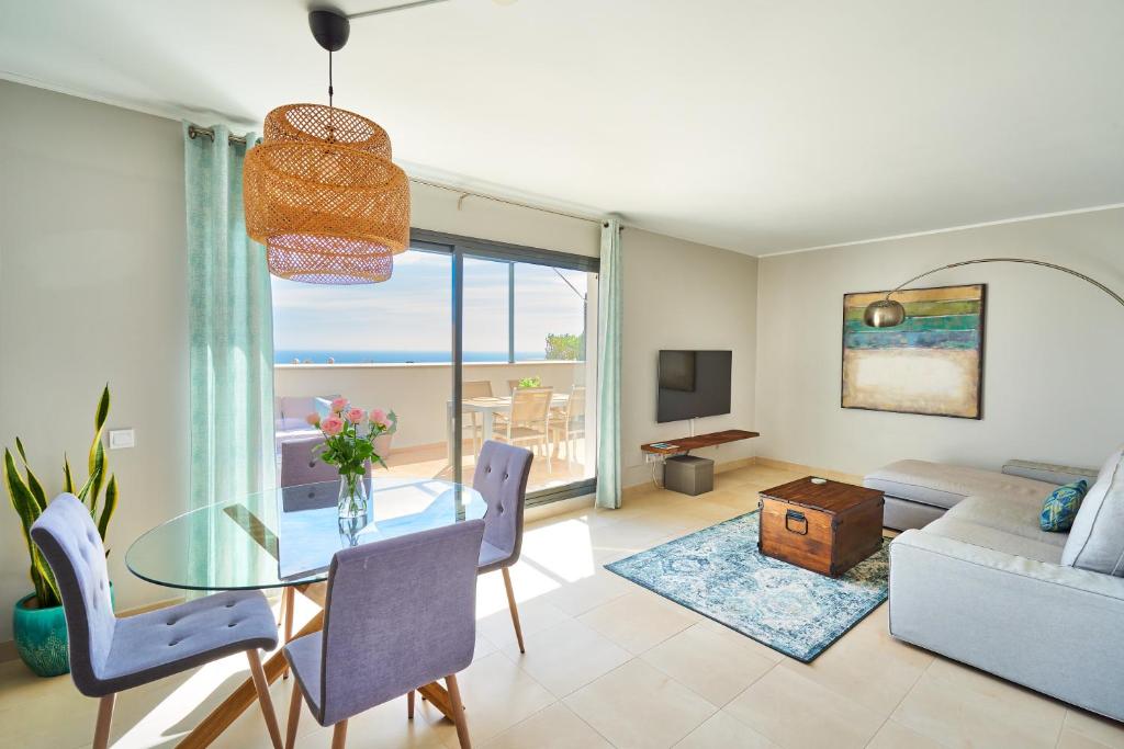 贝纳尔马德纳Sea View Penthouse, Pool, Privacy, Benalmadena的客厅设有玻璃桌,享有海景