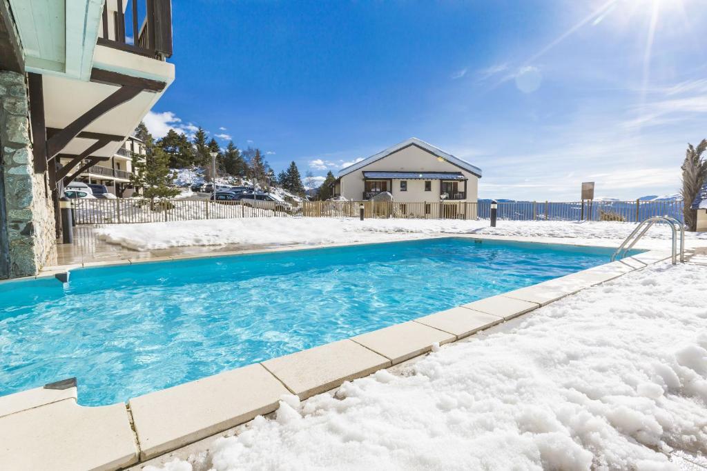 丰罗穆千阳欧达利斯公寓式酒店 的一座房子前面的雪覆盖的游泳池