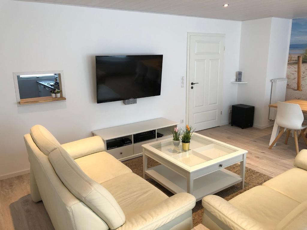 比德尔斯多夫Nordstern的客厅配有沙发和墙上的电视