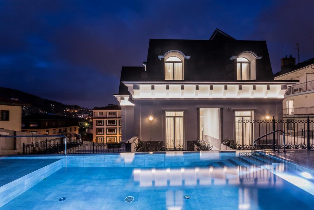 圣塞瓦斯蒂安Villa Eugenia Boutique Hotel的夜间带游泳池的别墅