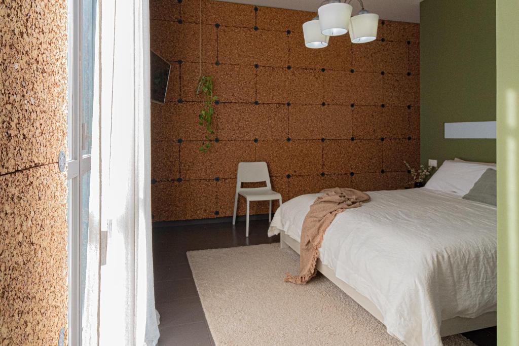 兰恰诺Lotus House的一间卧室配有一张床和一张白色椅子