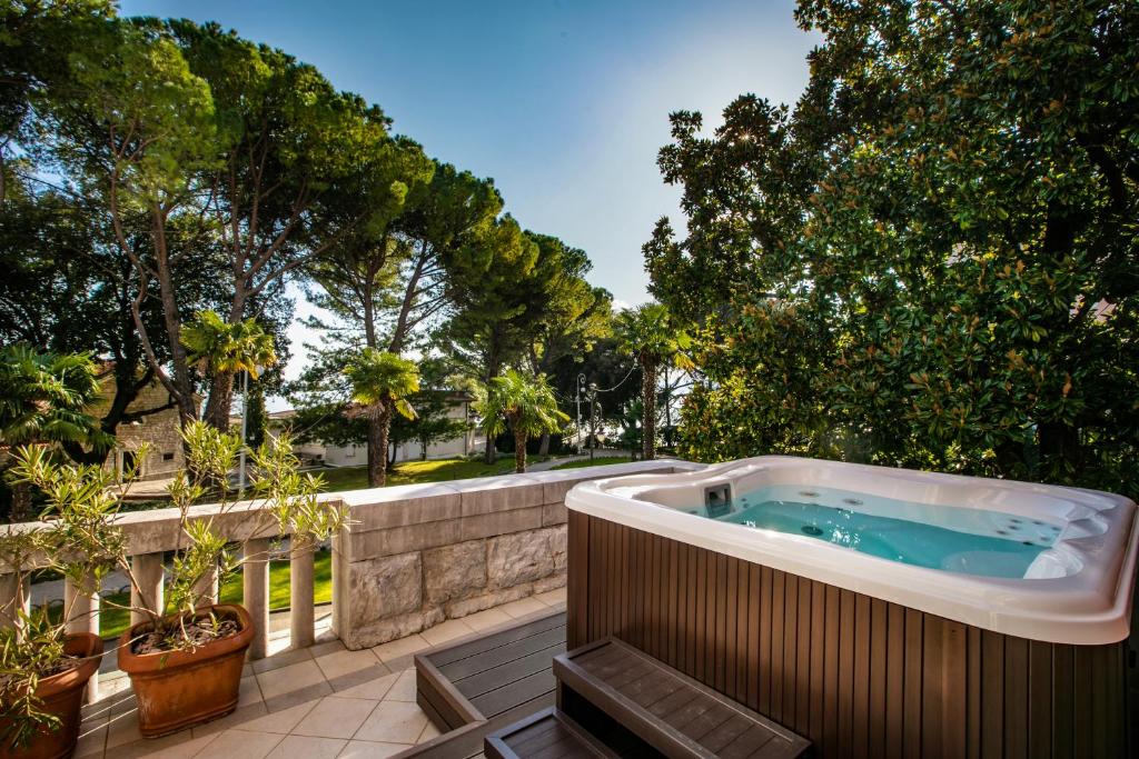 奥帕提亚Amadria Park Hotel Sveti Jakov的树木繁茂的庭院设有热水浴池。