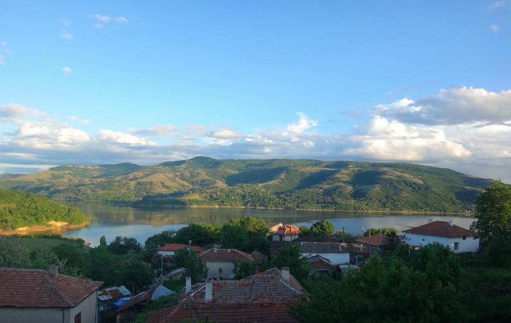 GnyazdovoMihaela Lake Retreat的享有湖泊和山丘的城镇景色