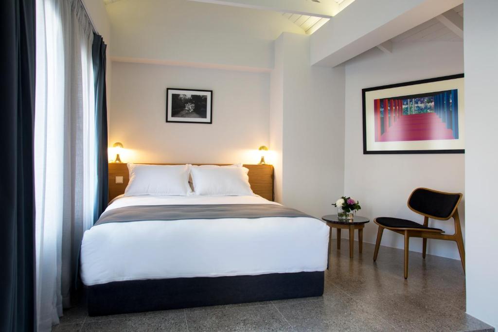 雅典沃尔5号酒店的一间卧室配有一张大床和一把椅子