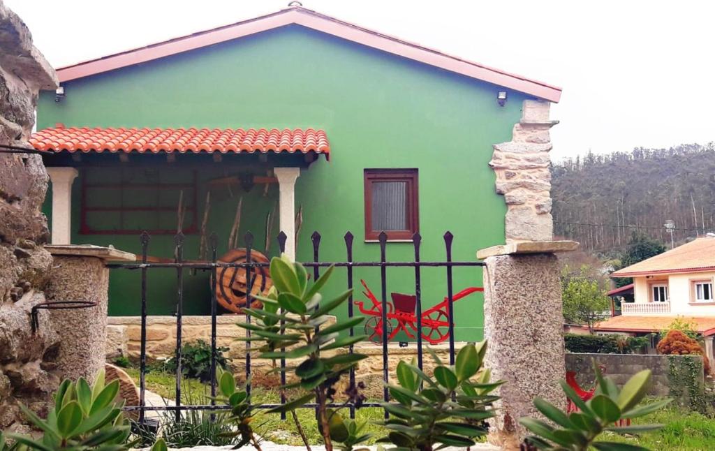 VimianzoCasa do Maestro - Costa da Morte的前面有栅栏的绿色房子