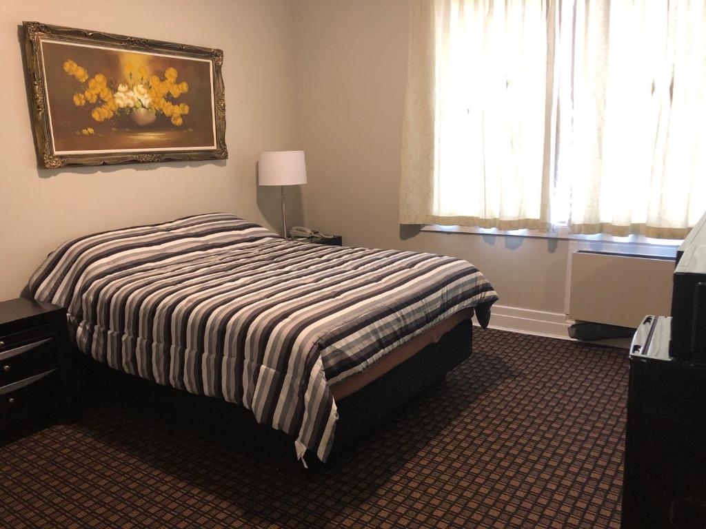弗林弗隆Royal Hotel的卧室配有一张床,墙上挂有绘画作品